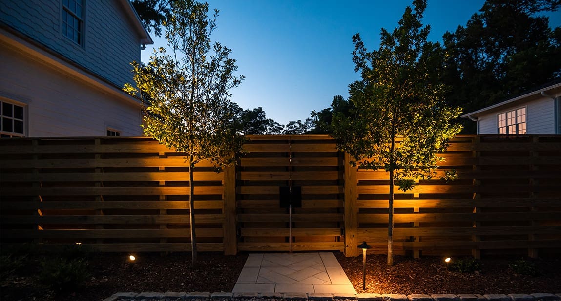 A beautiful backyard landscaping project at dusk with perfect lighting, designed and built by R&R Landscaping.