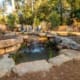 A peaceful backyard retreat that includes a water feature and fire pit sitting area. This outdoor living space was designed and built by R&R Landscaping.